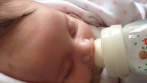 infant drinking from a bottle 