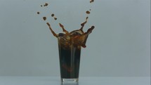 slow motion ice cube dropping into a cold brew glass