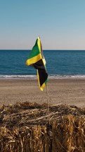 Waving Jamaica Flag On Top Of Hut On Beach