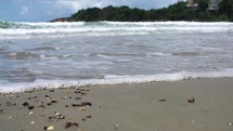 Beach coast water waves small crashing on sand - slow motion

