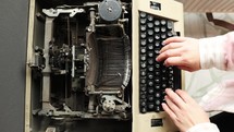 Overhead shot of hands on a nostalgic writer using a vintage typewriter.