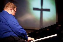 man playing a piano at a worship service