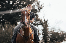 Horse riding woman on a brown stallion, western style saddle horseback rider