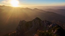 Sunset on a rocky mountain, Sun rays illuminate the mountain landscape, Panoramic shot. Time-lapse video