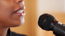 a woman speaking into a microphone 