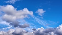 A Serene Sky with Fluffy White Clouds against a Deep Blue Canvas