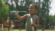 Little boy playing outdoor, blowing soap bubbles, having fun on backyard. Nature. 