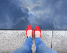 looking down at feet with red shoes 