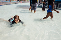 a child wading in shallow water in a public pool 