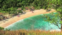 Secluded tropical beach with turquoise water and lush greenery 4k
