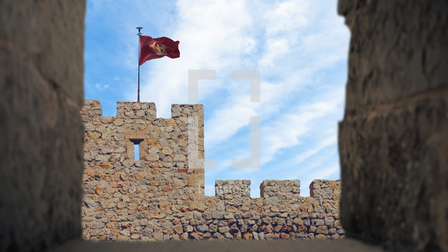 Roman Empire flag with the eagle fluttering in the wind on a military fort tower.
