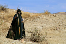 Hermit into a desert looking far away. Religious concept of enlightenment through fasting and prayer.
