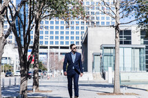 man walking in a city in a suit 