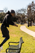 A man in workout clothes exercising in a park.