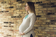 a pregnant woman holding her belly looking up