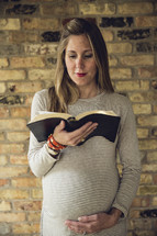 a pregnant woman reading a Bible 