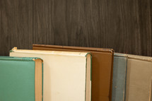 Border of vintage books on a dark wood background