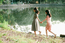 young women walking holding hands 
