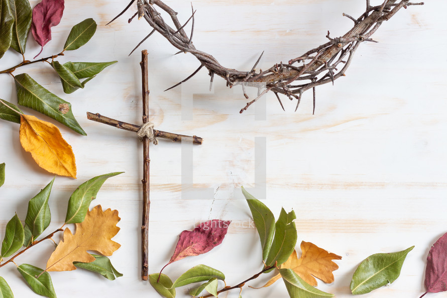 simple cross and crown of thorns on a white wood background 