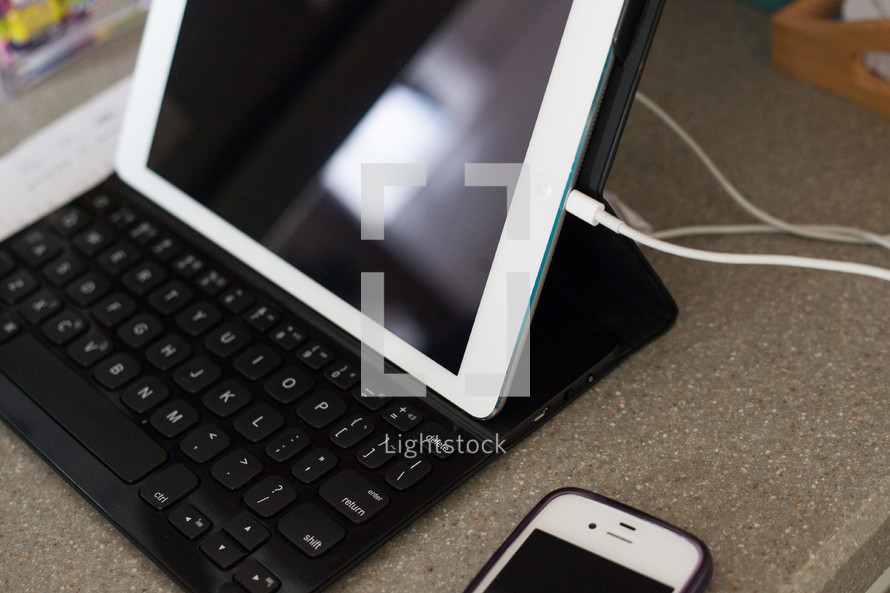 iPad with a keyboard and cellphone 