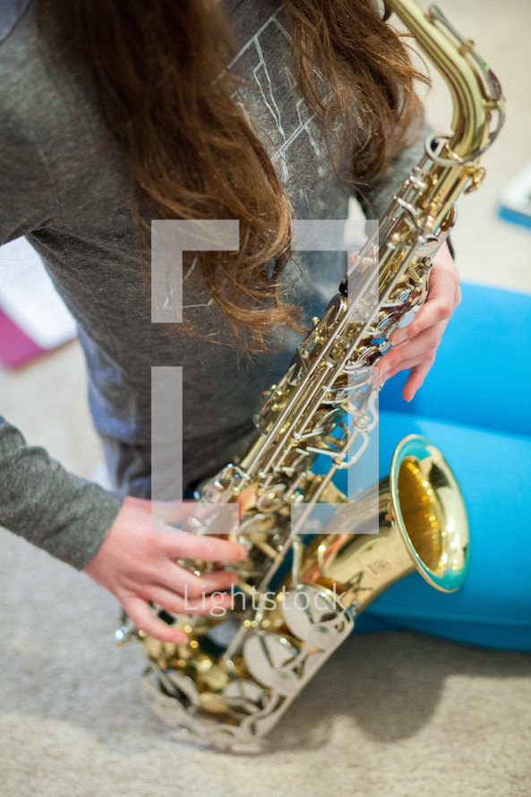 teen girl playing a saxophone 