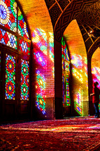 colors from stained glass windows shining on a rug in a mosque 