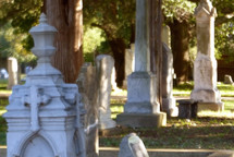 soft focus cemetery with old carved monuments and sunny side lighting