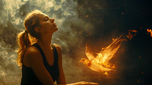 A young adult woman with her eyes closed with a fiery dove approaching