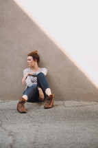 young woman sitting on concrete 