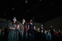 parishioners holding candles during a worship service 