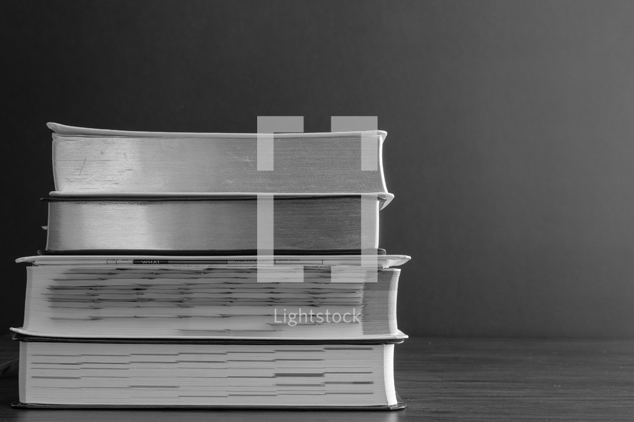 Black and white stack of bibles on a black background 