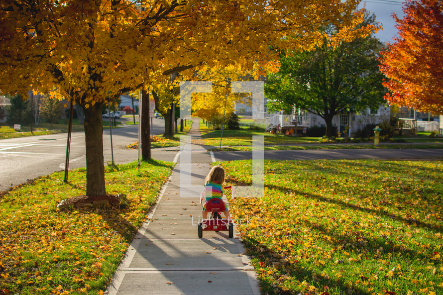 a toddler girl on a tricycle 