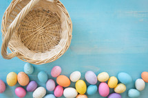 Border of easter eggs and empty basket on a blue background