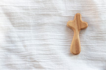 wooden cross on white linen 
