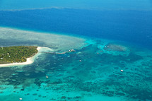 aerial view over island and coral reef 