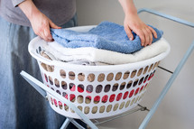 Girl with Stack of towels in washing basket