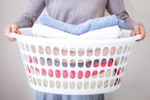 Lady holding washing basket with towels