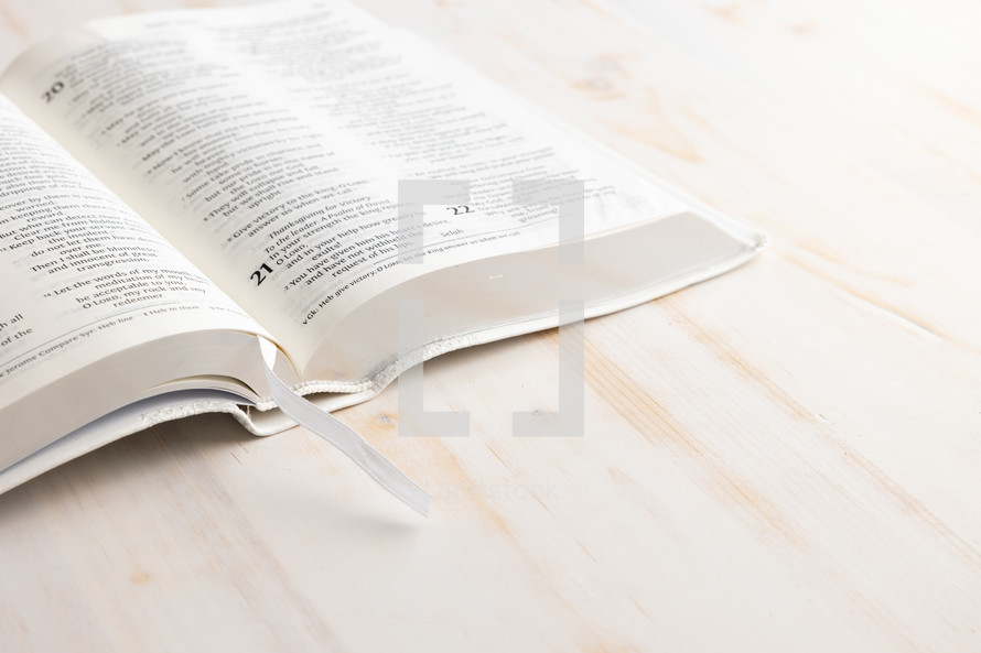 open BIble on white wood background 
