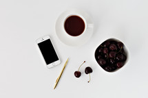 iPhone, pen, cherries, and coffee cup 