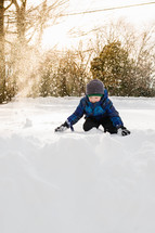 boy child playing in snow 