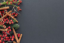 red berries and Christmas greenery on a black background with copy space 
