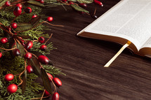 Christmas garland with berries and open Bible
