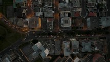 Aerial top down shot of downtown buildings of Quito, with skyscraper and high-rising towers at dusk - Traffic driving on road in Ecuador