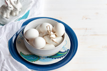 bowl of eggs and porcelain bunnies 