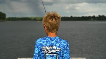 a boy child fishing off a dock 