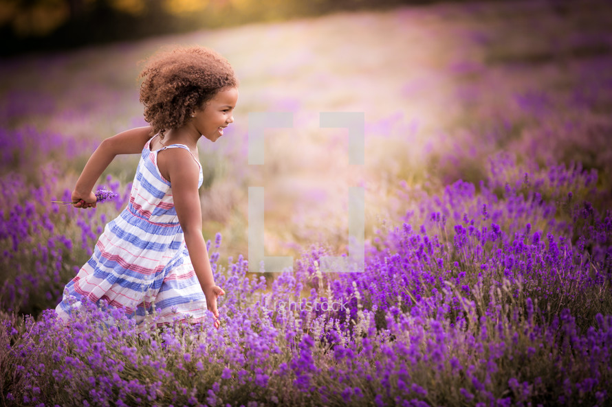 a little girl running in a lavender field 