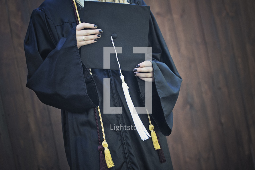 a teen girl holding a graduation cap 