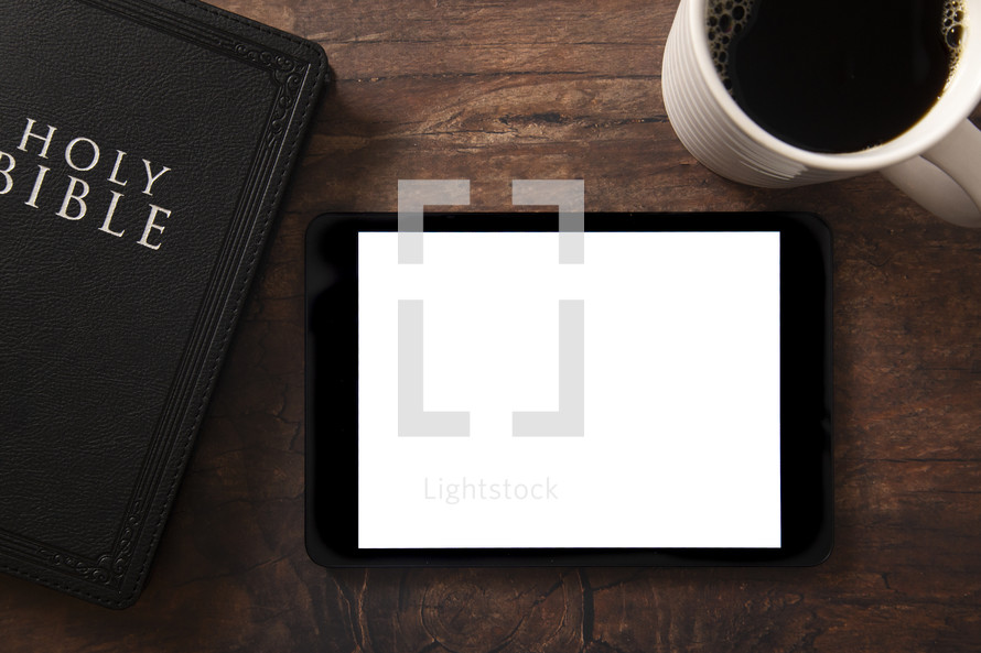 tablet, Bible and coffee cup on a wood background