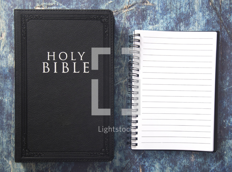 notebook and Bible on a blue grunge background 