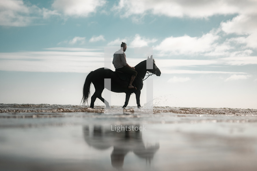 Horse riding on a beach, equestrian man riding on a horse